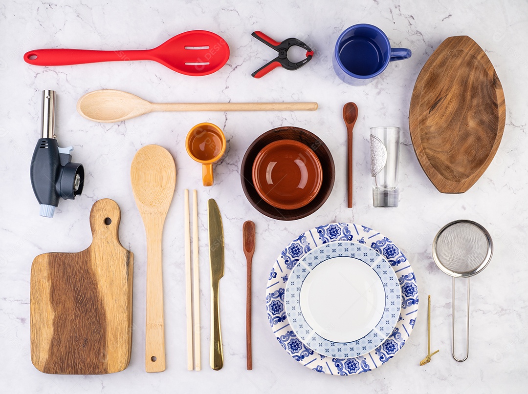 Utensílios de cozinha variados sobre fundo de mármore.