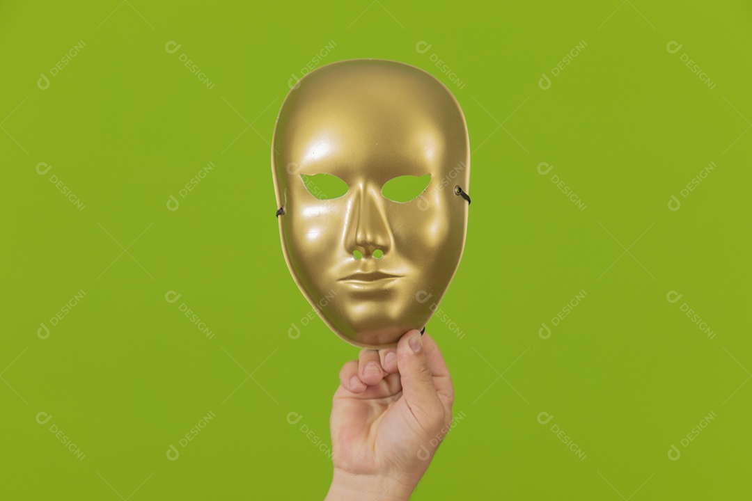 Homem jovem garoto barbudo segurando máscara dourada sobre fundo isolado