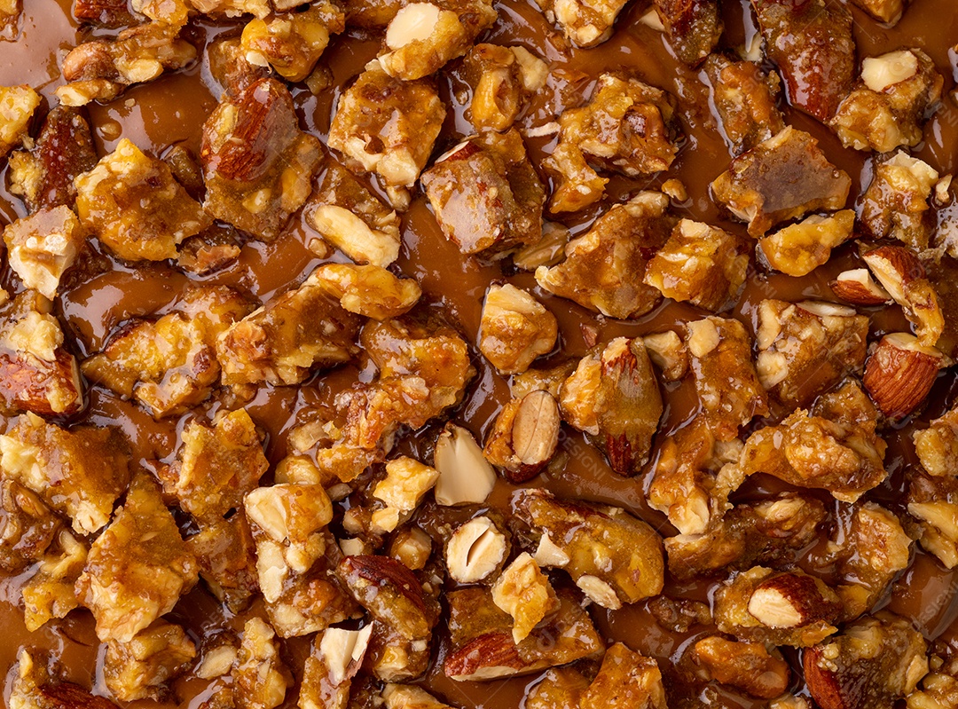 Close up da cobertura do cheesecake de praliné de amêndoa e noz.