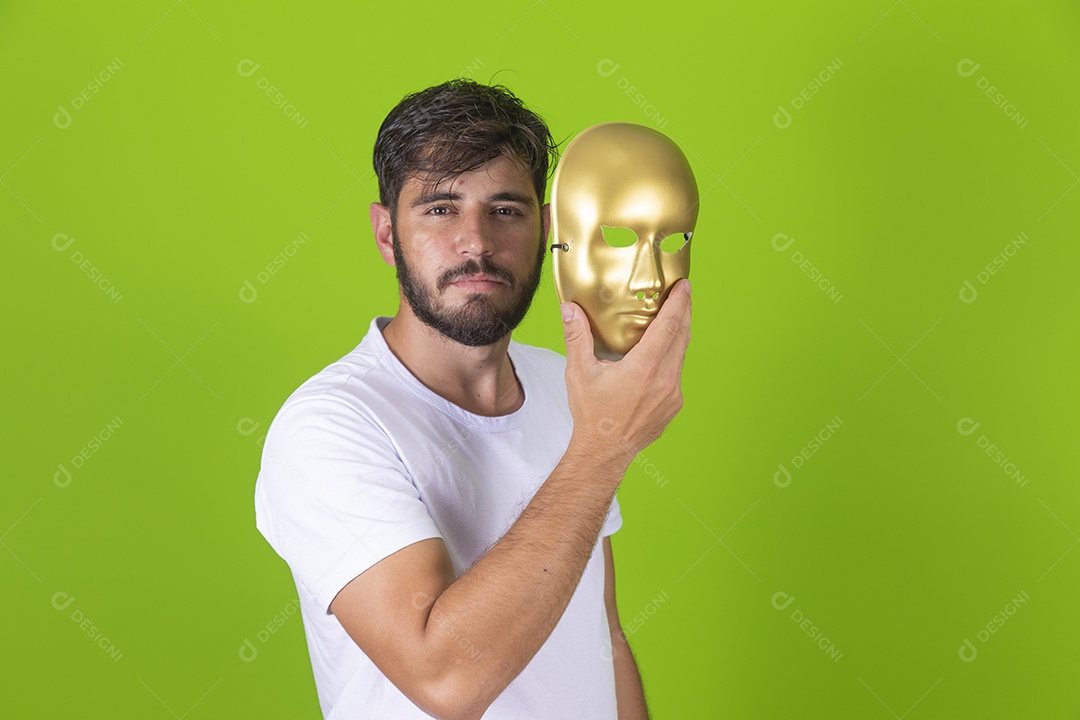 Homem jovem garoto barbudo segurando máscara dourada sobre fundo isolado