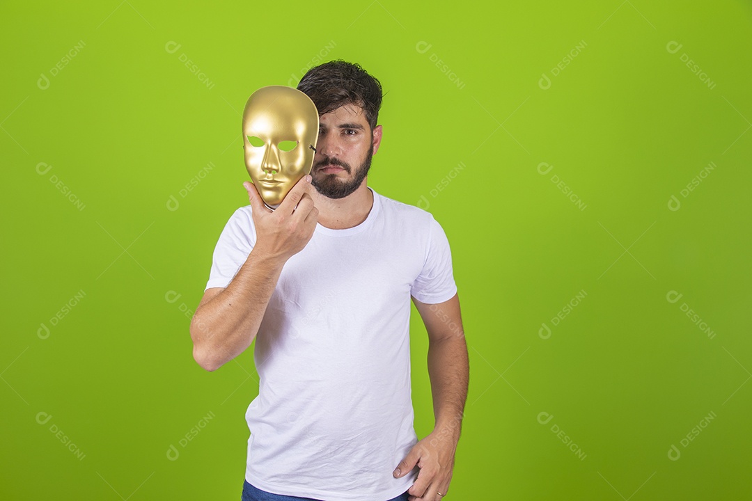 Homem jovem garoto barbudo segurando máscara dourada sobre fundo isolado
