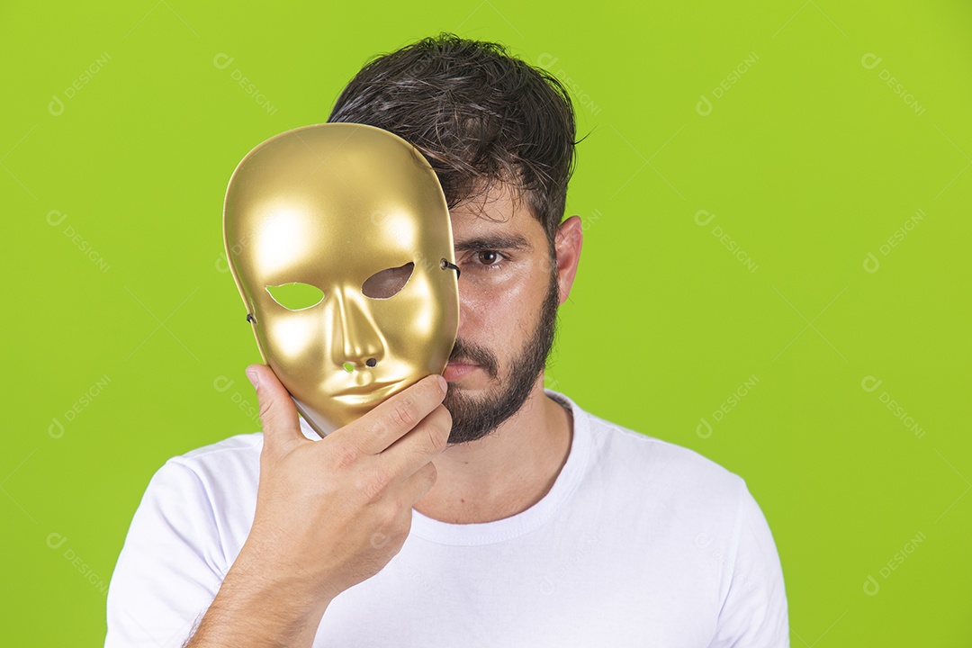 Homem jovem garoto barbudo segurando máscara dourada sobre fundo isolado