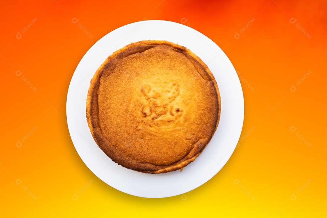 Bolo de mandioca de vista superior com fundo gradiente laranja.