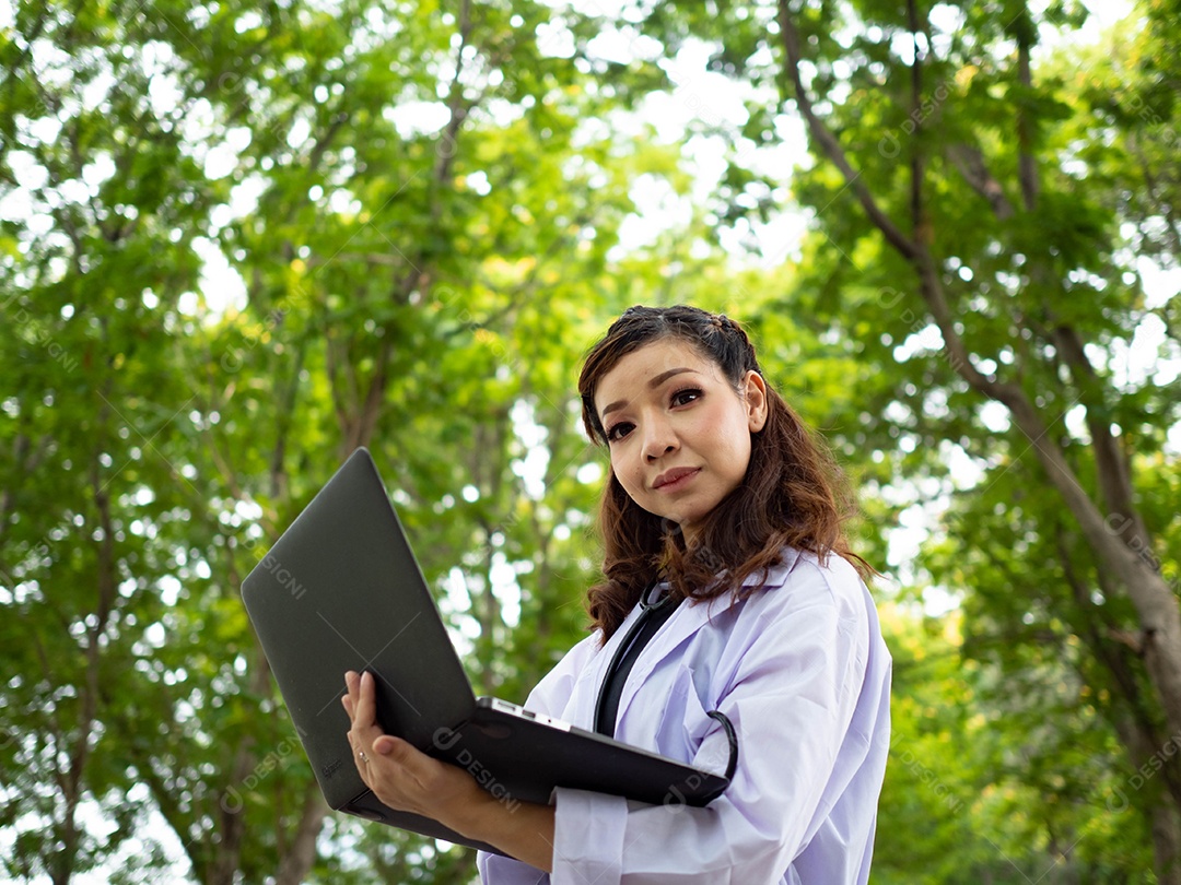 Enfermeira segurando notebook ao ar livre