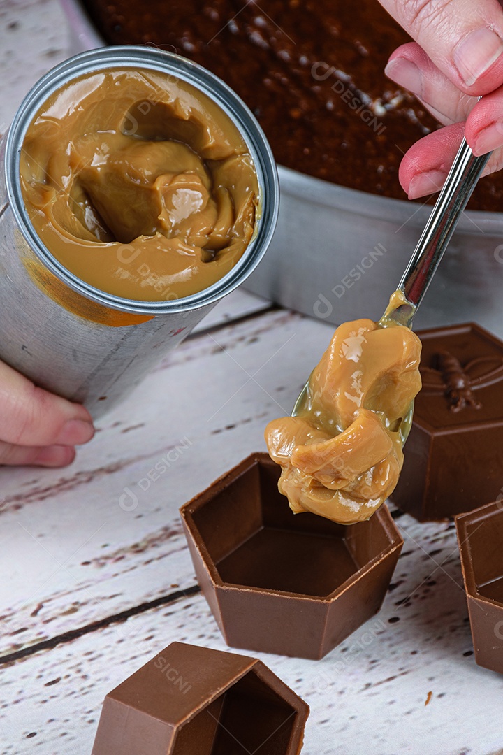 Confeiteiro colocando doce de leite em forminhas de chocolate