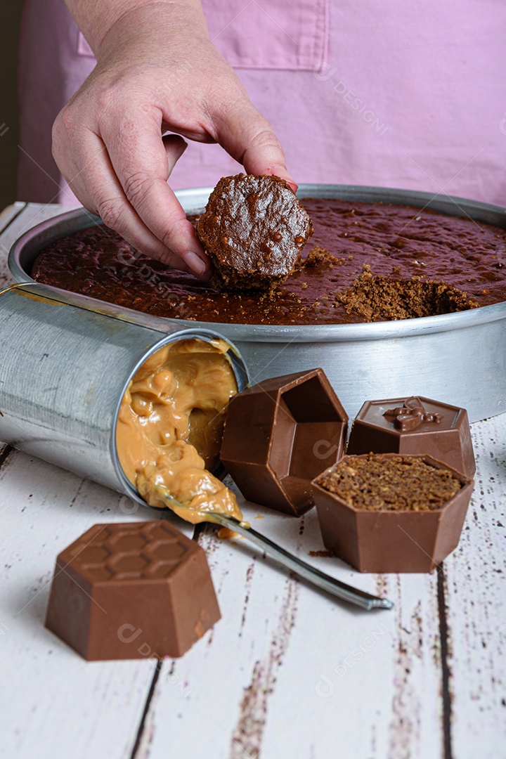 Confeiteiro pegando um pequeno bolo de mel brasileiro