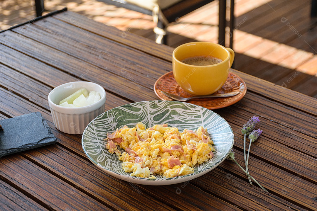 Ovos mexidos com presunto ao lado de uma porção de melão, xícara de café