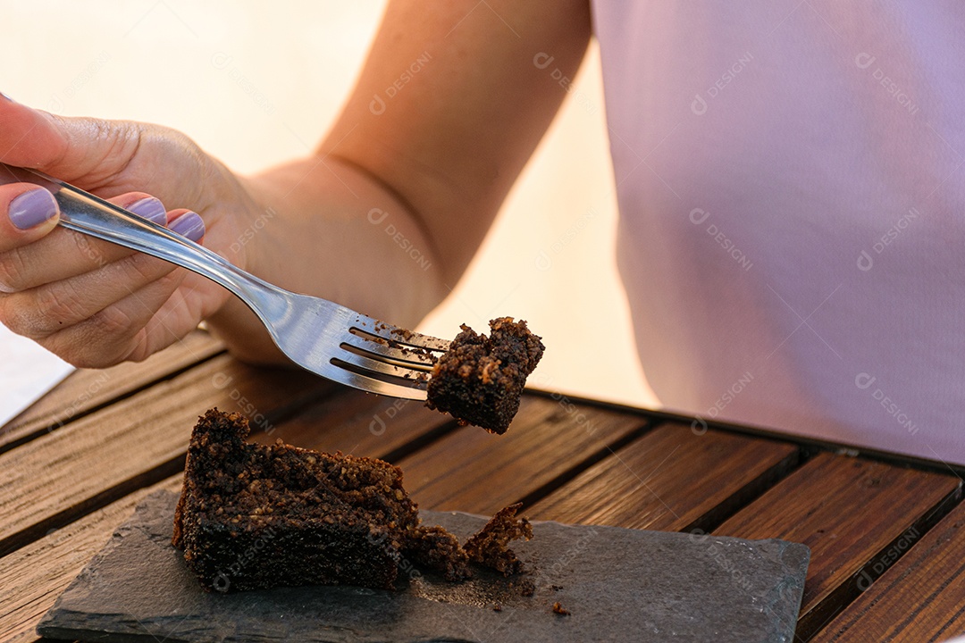 garfo com pedaço de bolo de biscoito, ao lado de uma pedra de ardósia.
