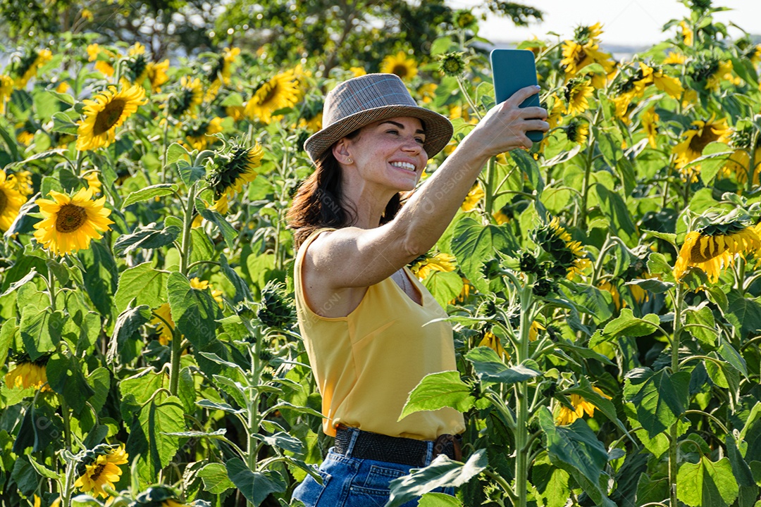 Mulher brasileira com chapéu fazendo uma foto de si mesmo