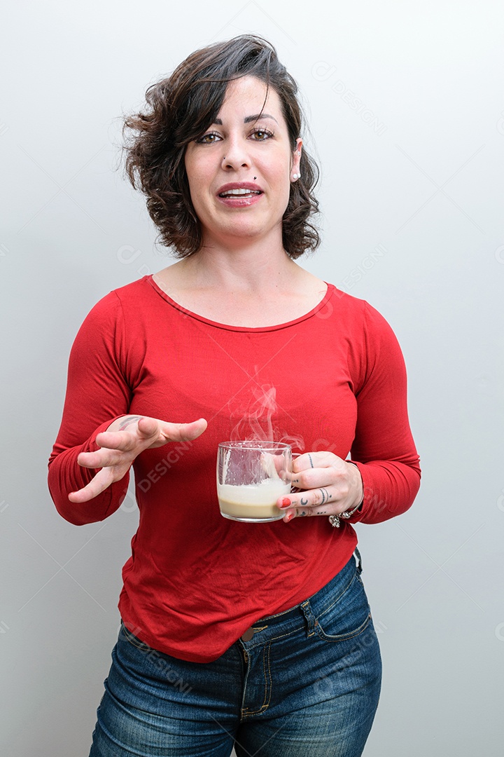 Foto espontânea. Mulher brasileira com a mão aberta, segurando uma caneca de cappuccino