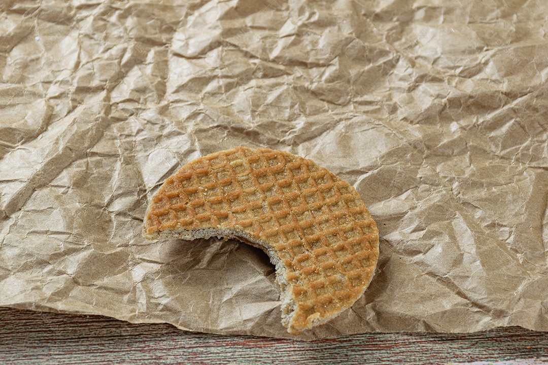 Stroopwafel closeup com uma mordida em um papel pardo