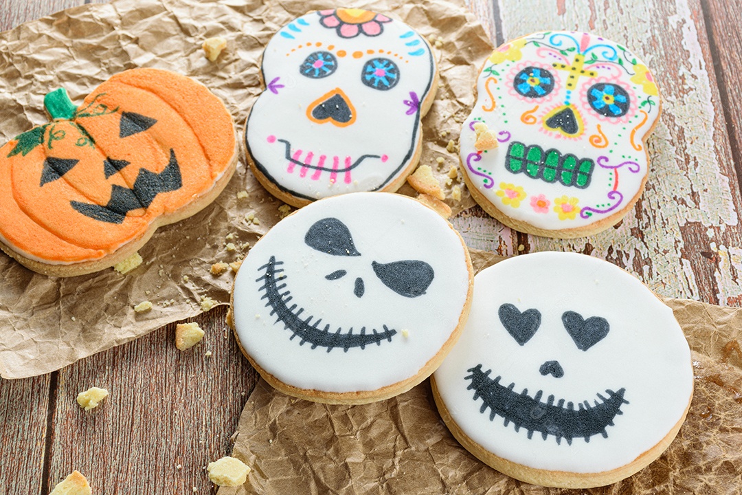 Biscoitos amanteigados temáticos de Halloween ao lado de migalhas.