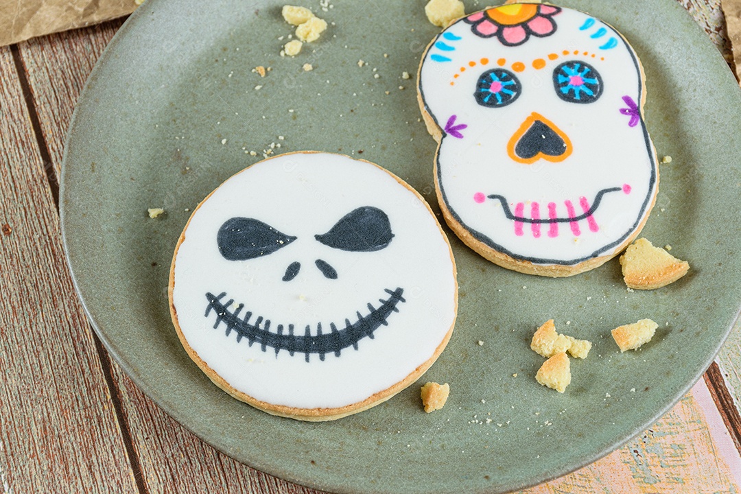 Close up de biscoitos amanteigados temáticos de Halloween em um prato verde.