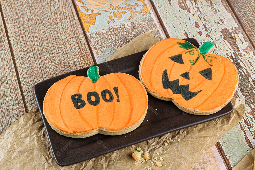 Pumpkin-shaped shortbread cookies on a brown plate