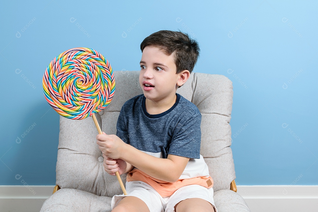 Criança de 8 anos segurando um grande pirulito colorido