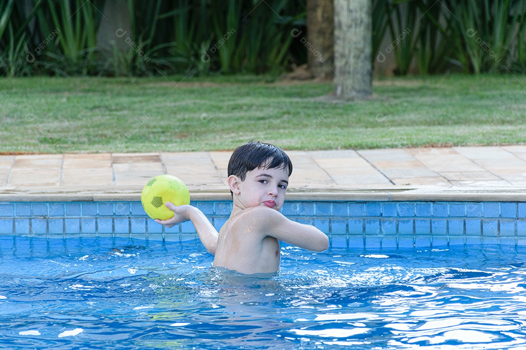 8 year old child in the pool playing ball.