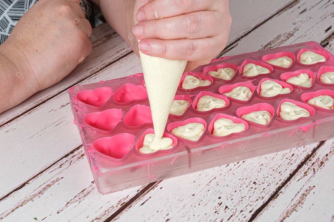 Detalhe do padeiro usando um bico de confeiteiro para rechear chocolate