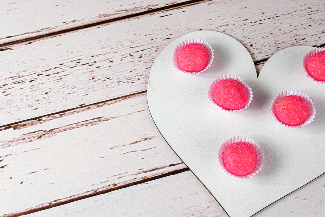 Porção de bicho de pe sobre tábua de madeira em forma de coração