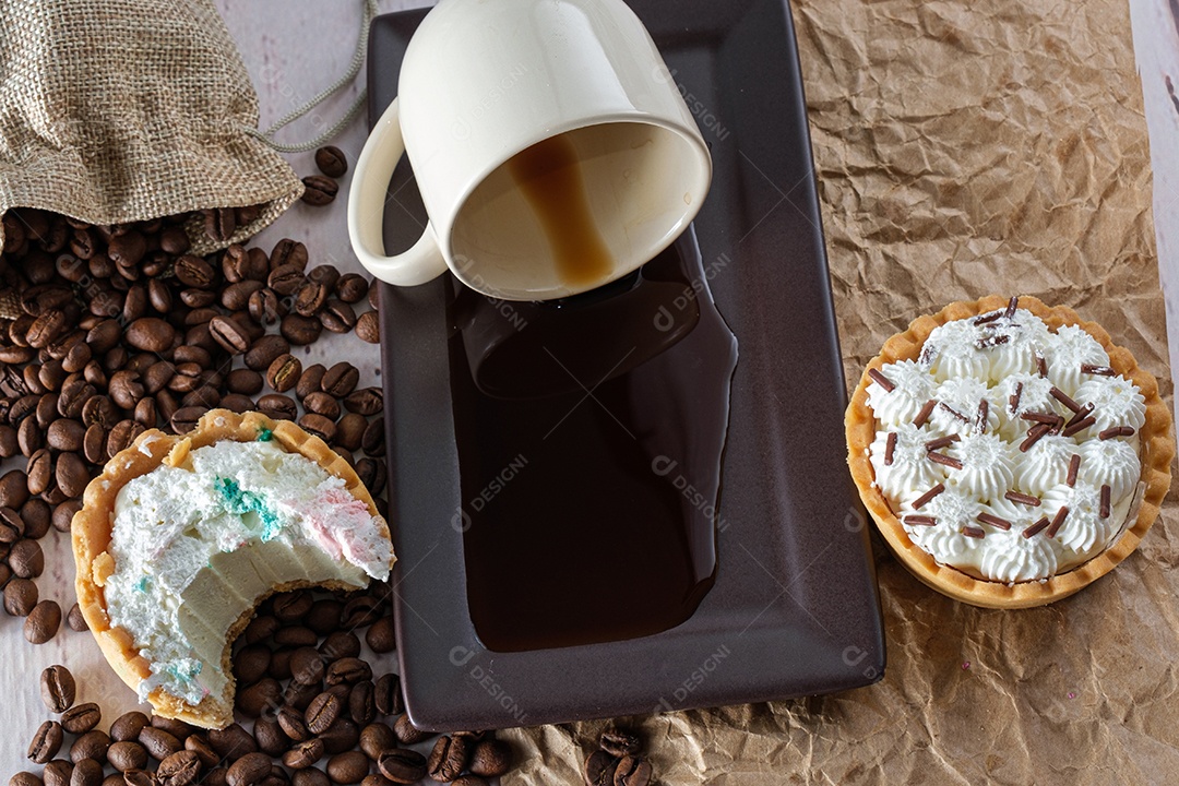 Mini torta de ganache de chocolate branco com uma mordida, ao lado de uma xícara de café