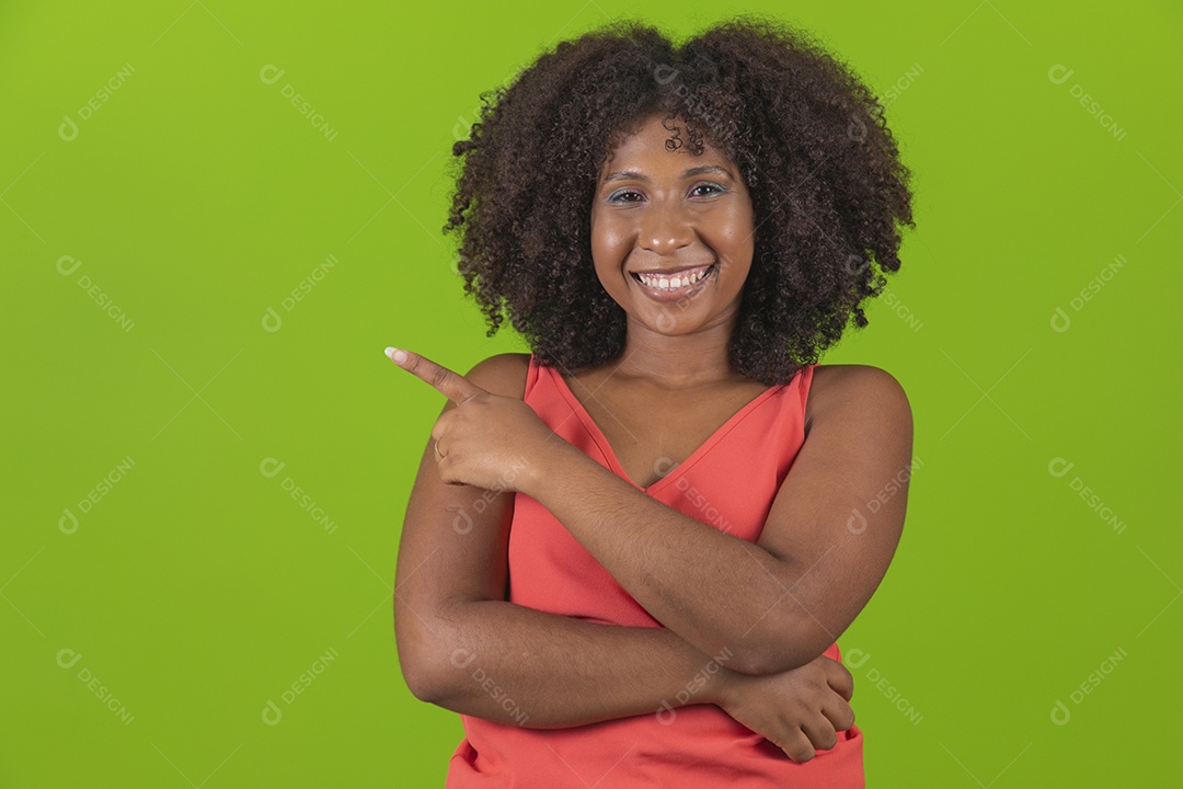 Linda mulher jovem morena cabelo cacheado sorridente apontado para lado