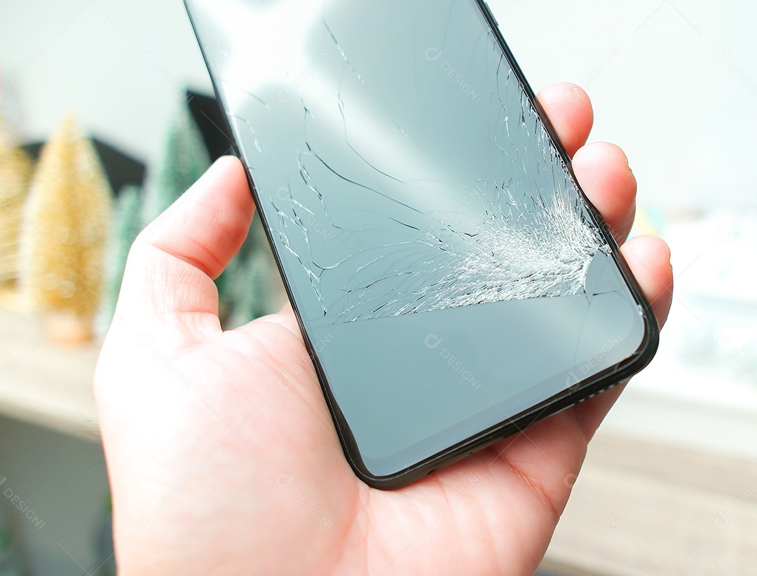 Smartphone com tela rachada na mão, objeto isolado