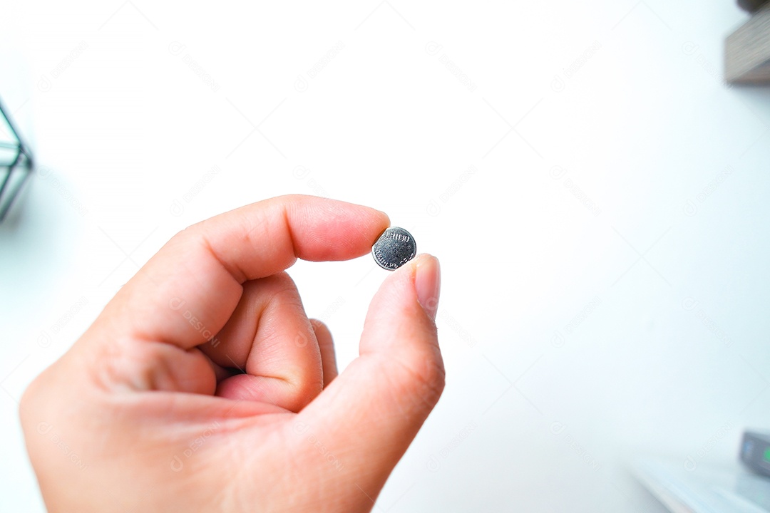 Bateria de célula tipo moeda ou botão LR1130 na mão, objeto isolado