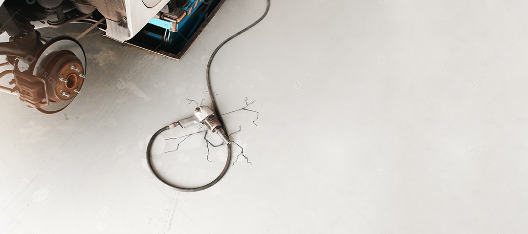 Chave de impacto de ar com mangueira de borracha no chão no reparo de automóveis