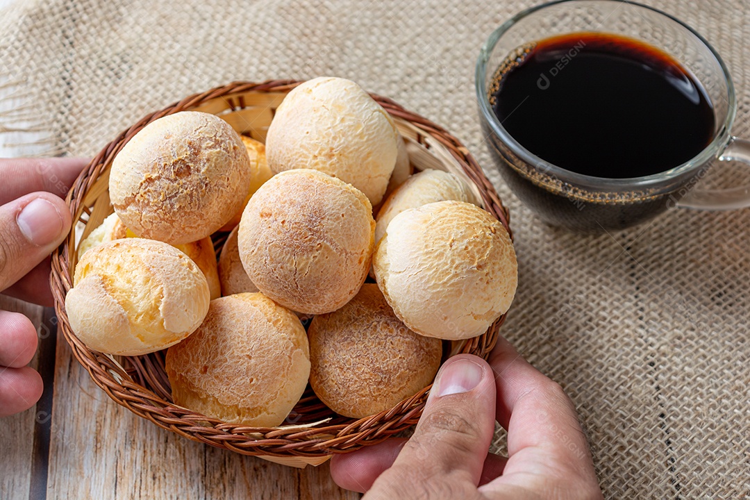 Homem serve pão de queijo na mesa de madeira, tradicional brasileiro