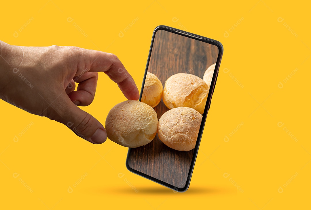 Mão pegando pão de queijo de dentro da tela do smartphone, concentrado