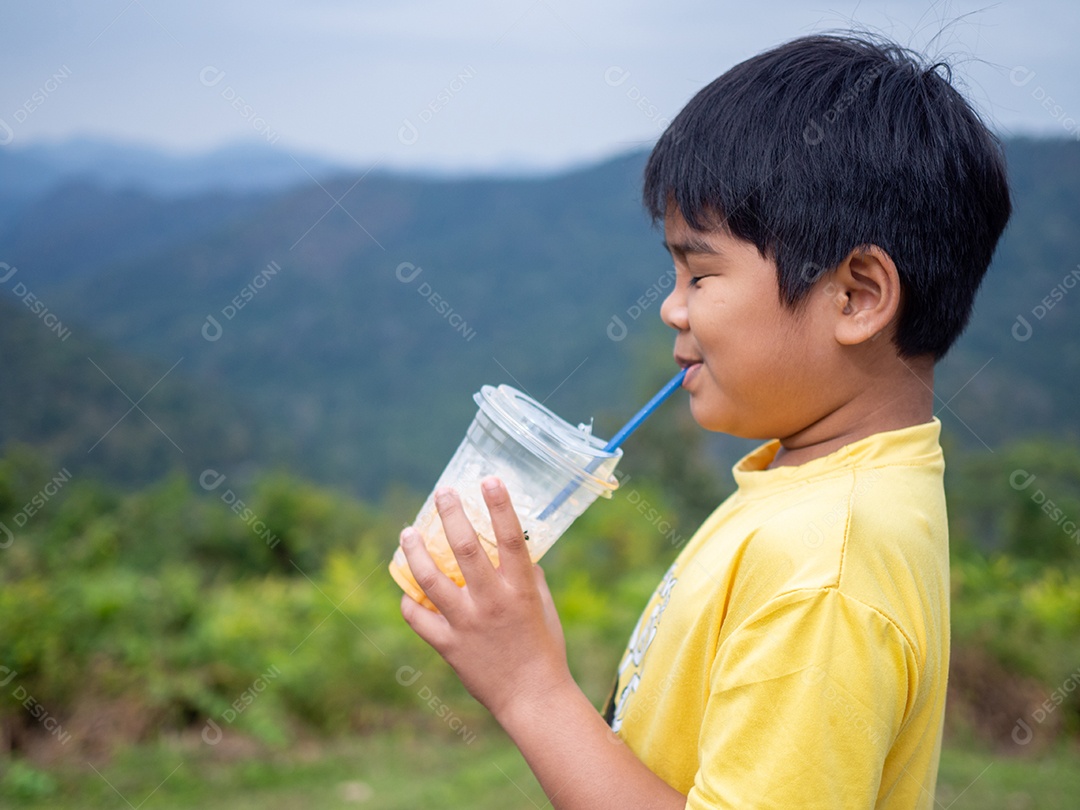 Menino tomando uma bebida de um copo com fundo de vale