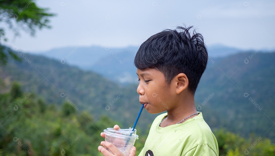 Menino tomando uma bebida de um copo com fundo de vale