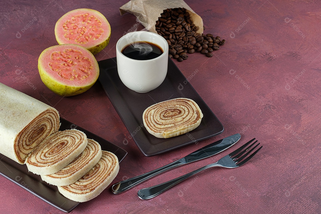 Fatia de Bolo de Rolo Rodeada de Goiabada, Xícara e Grãos de Café