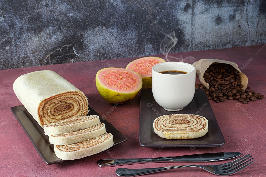 Fatia de Bolo de Rolo rodeada de Goiabada, Xícara e Grãos de Café