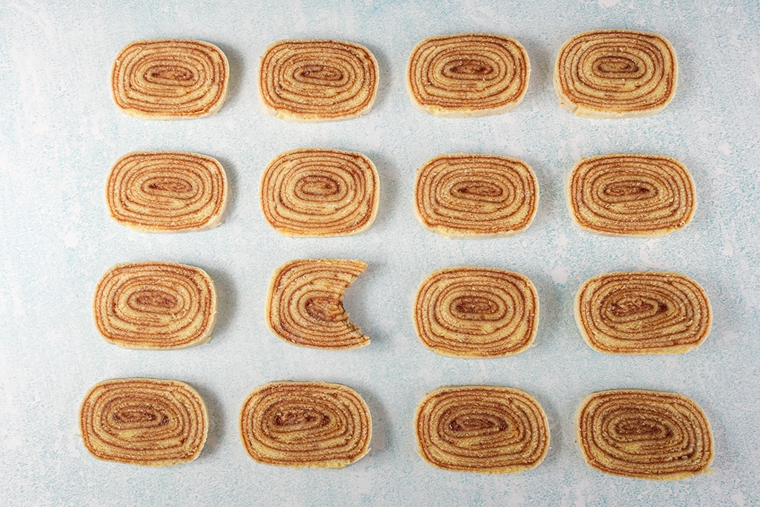 Uma fatia de bolo de rolo com uma mordida cercada por outras fatias.