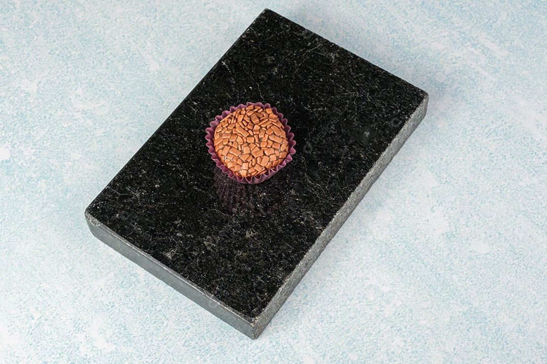 Brigadeiro sobre pedra mármore preto brilhante.