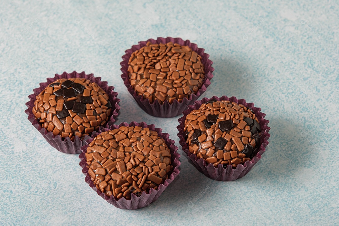 Brigadeiros tradicionais e amargos em um fundo azul claro