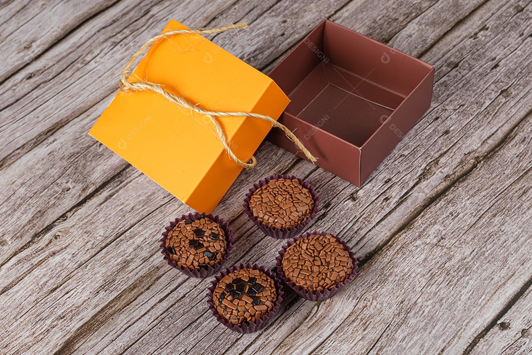 Brigadeiros amargos e tradicionais ao lado de uma caixa aberta.