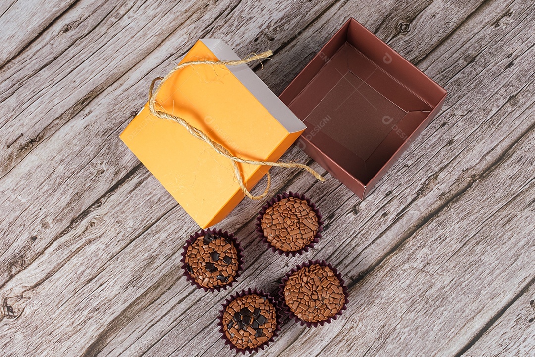 Brigadeiros amargos e tradicionais ao lado de uma caixa aberta.