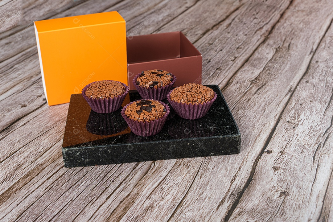 Brigadeiros amargos e tradicionais em pedra mármore preta