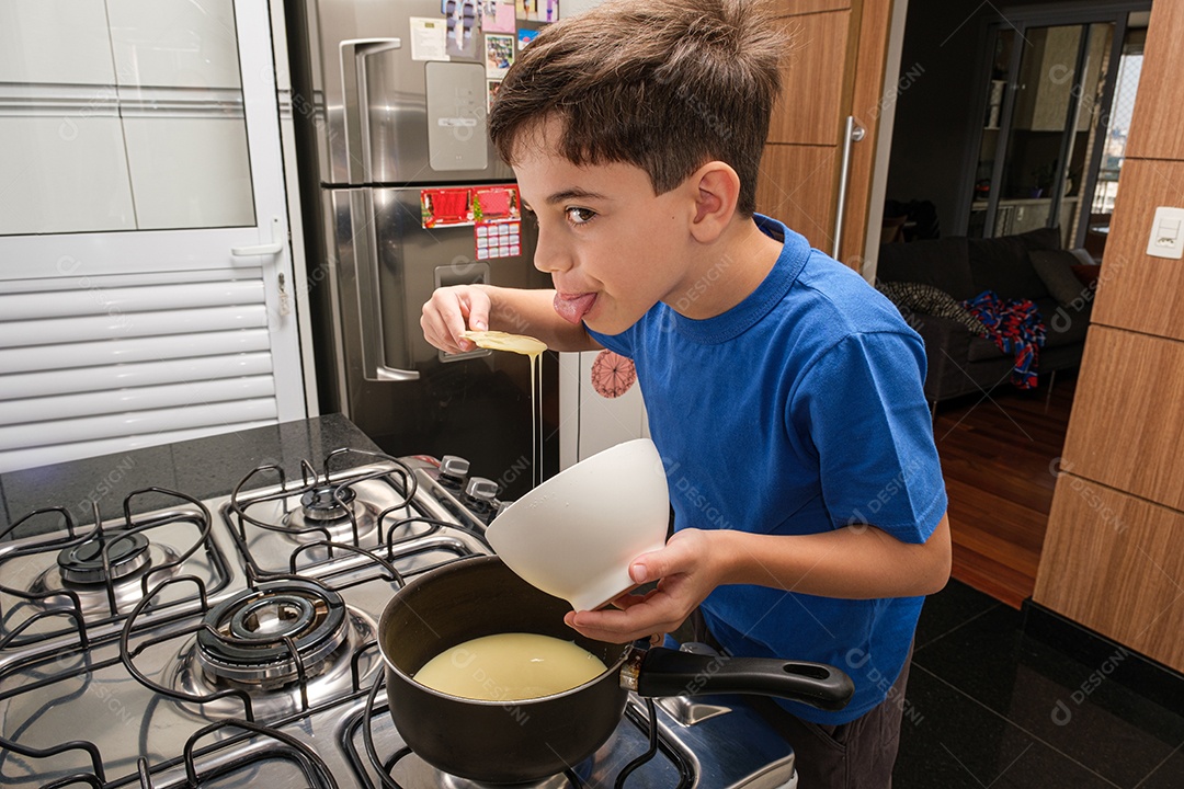 Criança de 8 Anos na Cozinha Sorrindo e Colocando Leite Condensado na Panela