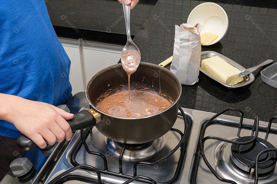 Criança com uma colher verificando a textura do brigadeiro