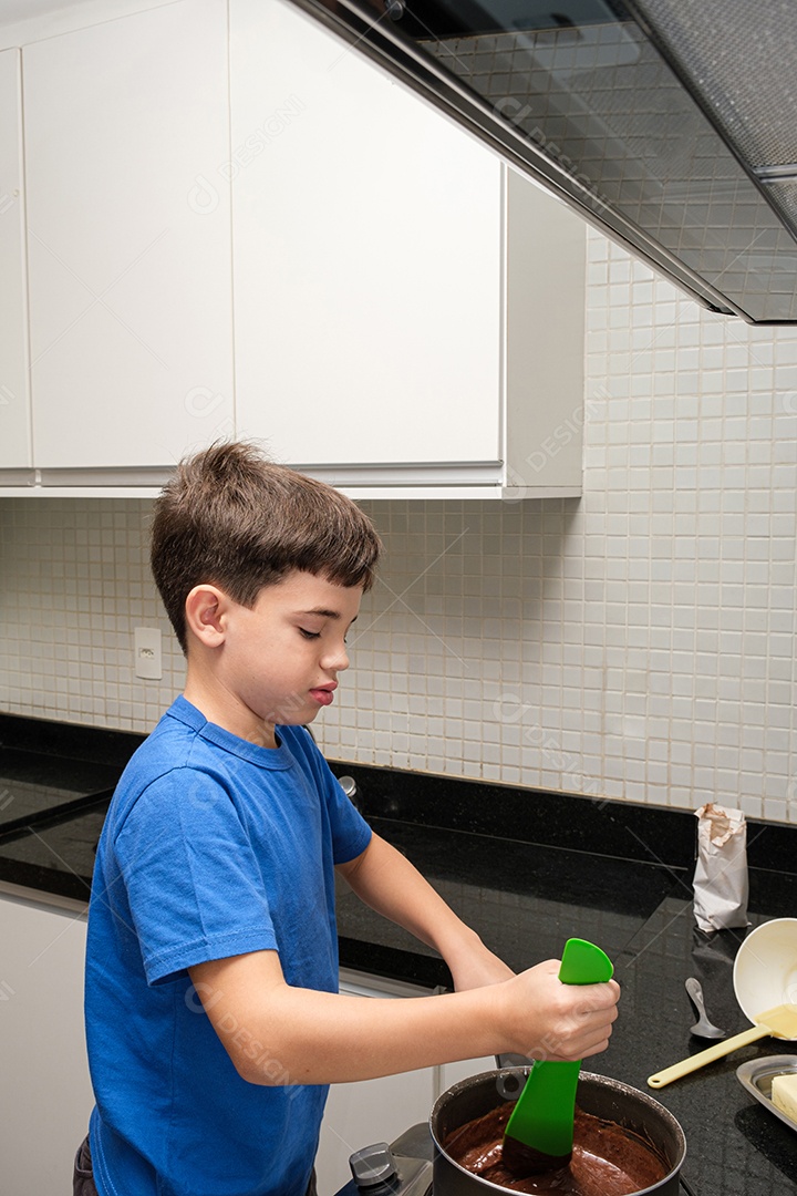 Criança de 8 anos na cozinha mexendo brigadeiro