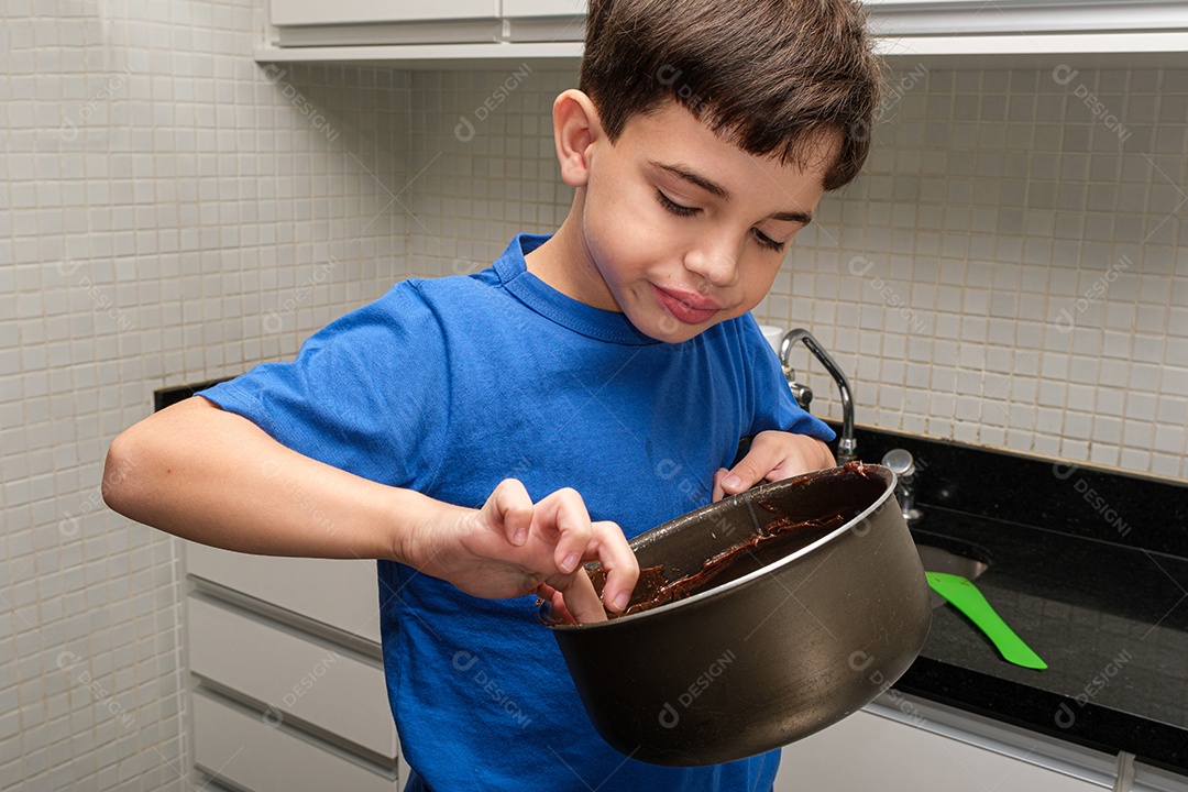 Criança de 8 anos na cozinha pegando brigadeiro