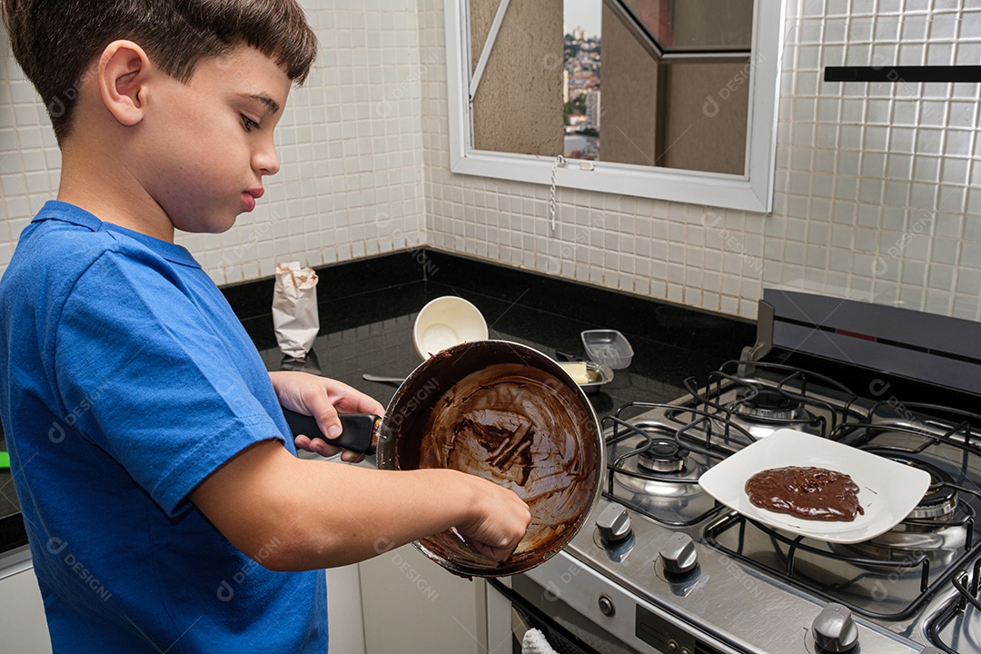 8 anos na cozinha, mexendo na panela com brigadeiro