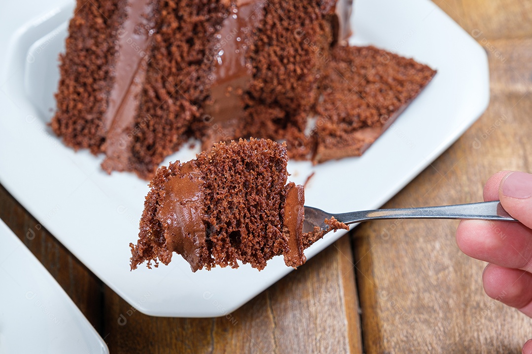 Detalhe de um pedaço de bolo de chocolate com chocolate meio amargo