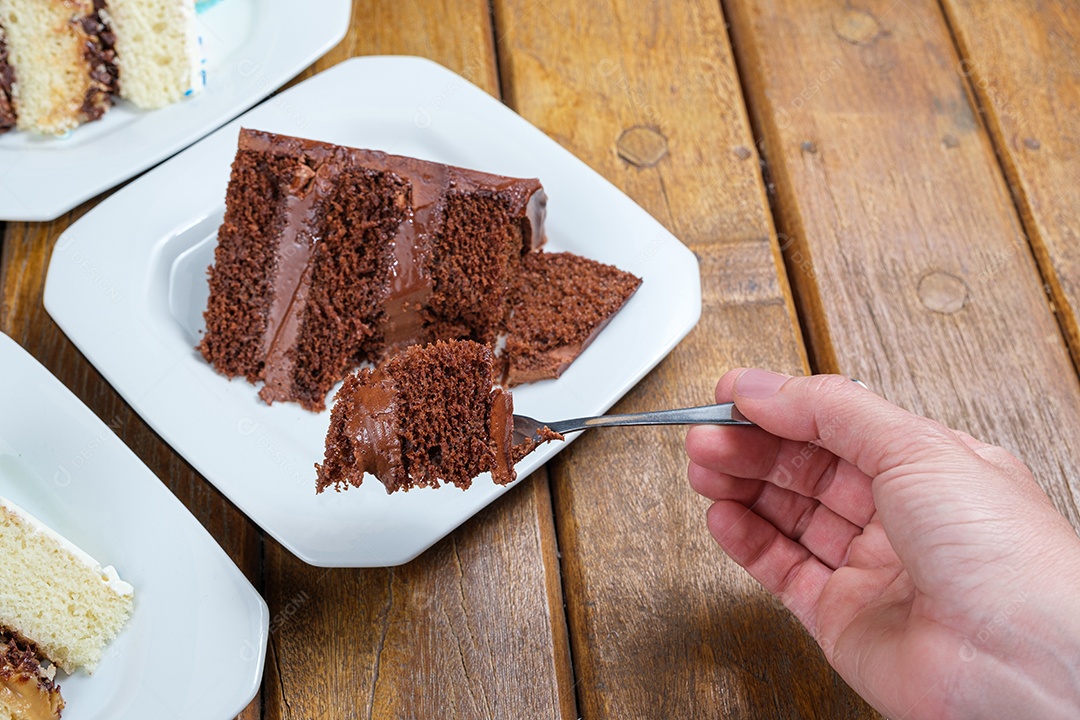 Mulher segurando um pedaço de bolo de chocolate com chocolate meio amargo
