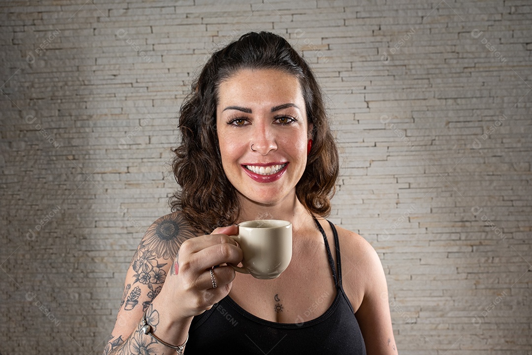 Mulher tatuada brasileira com um grande sorriso, de frente para a câmera