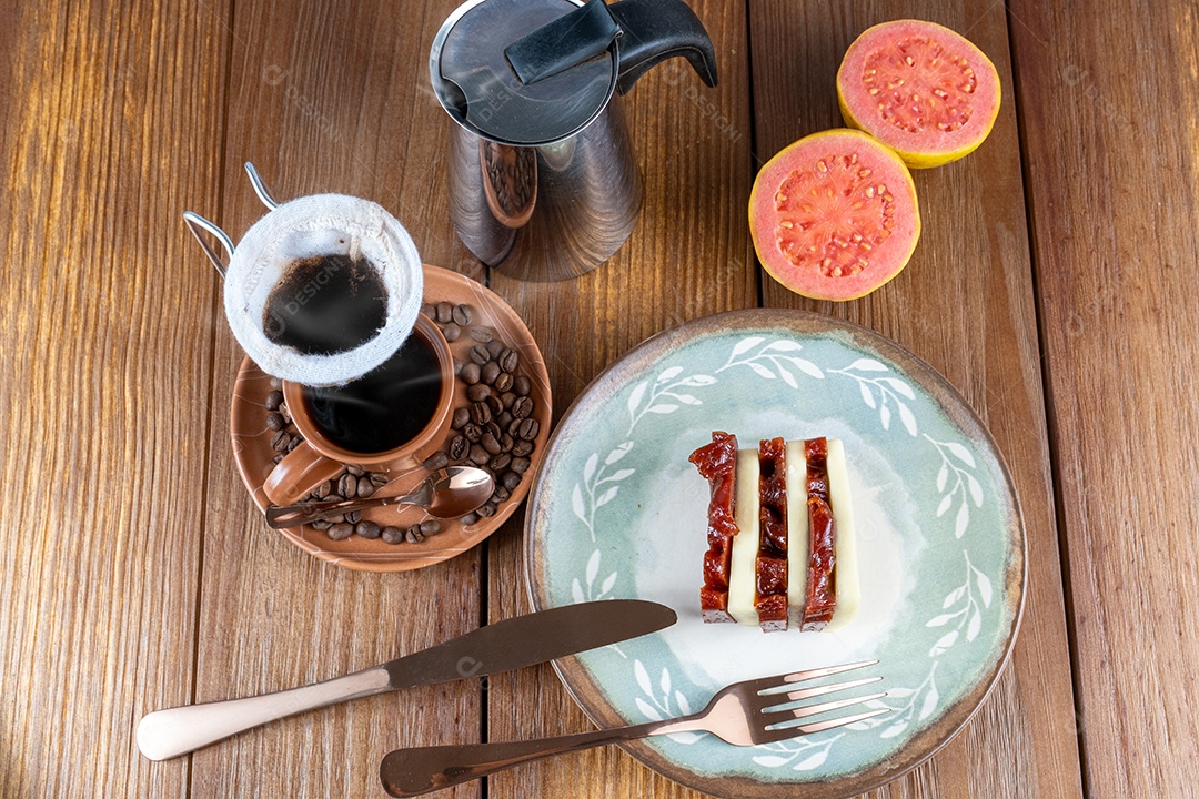 Doce de goiaba e fatias de requeijão ao lado de talheres