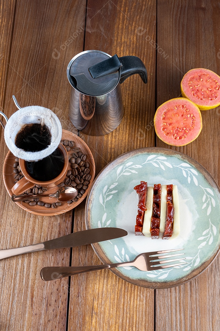 Doce de goiaba e fatias de requeijão ao lado de talheres
