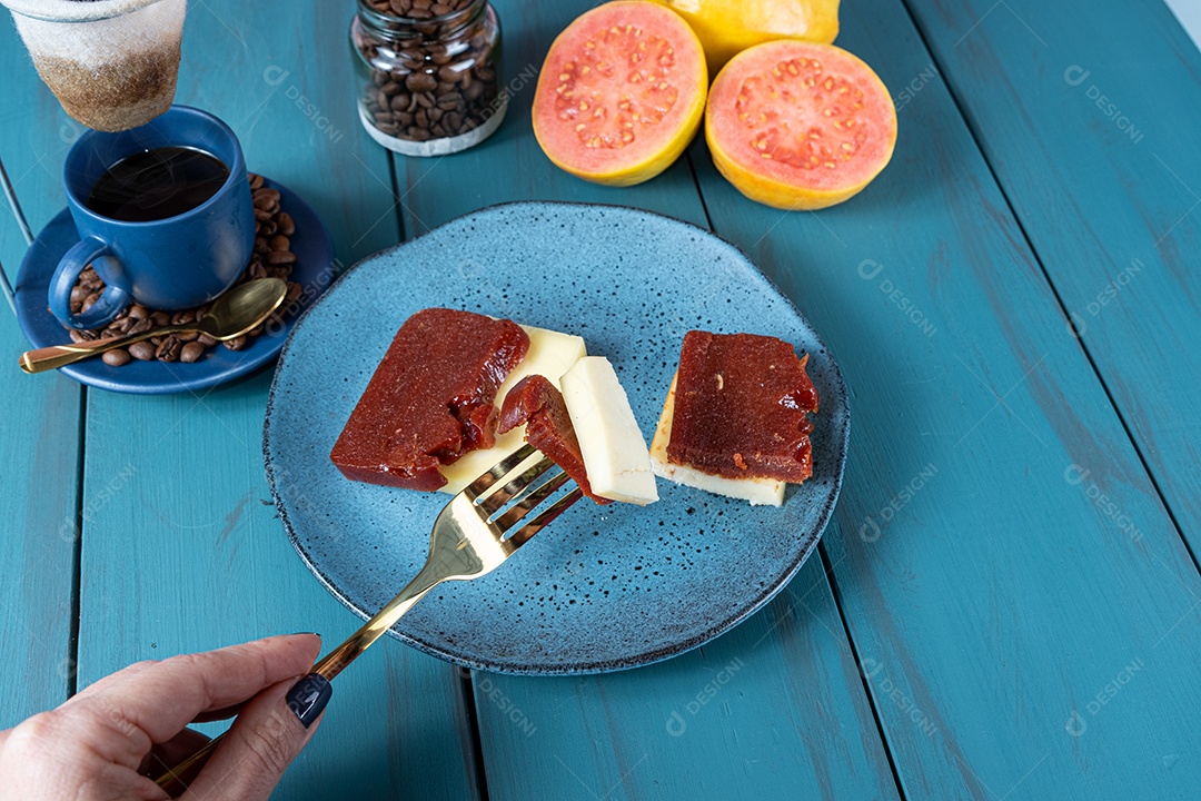 Mulher segurando um garfo sobre fatias de doce de goiaba com queijo